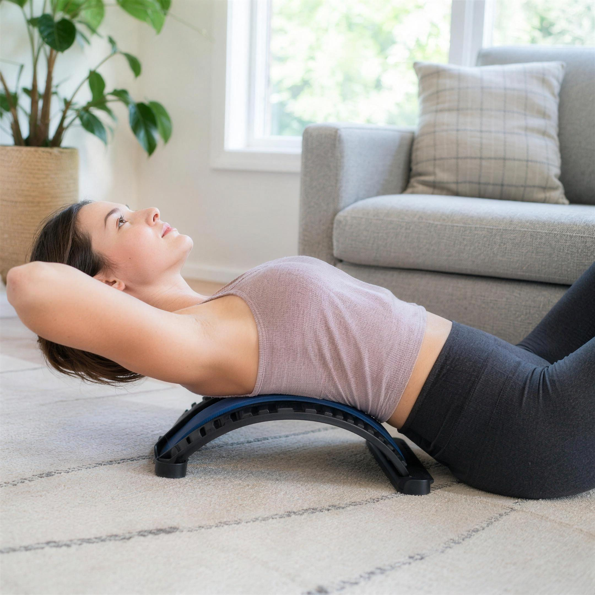 Woman lying back over the lumbar stretcher to stretch her lower back