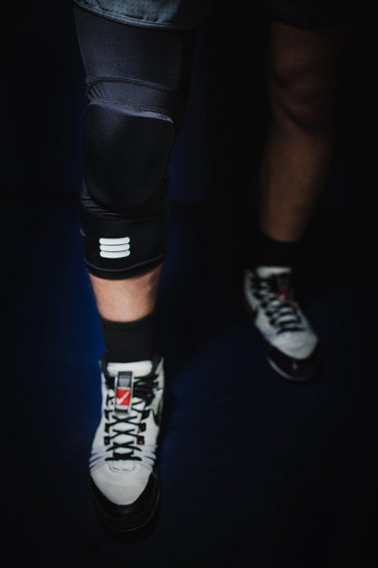Padded knee sleeve worn on the leg with sneakers